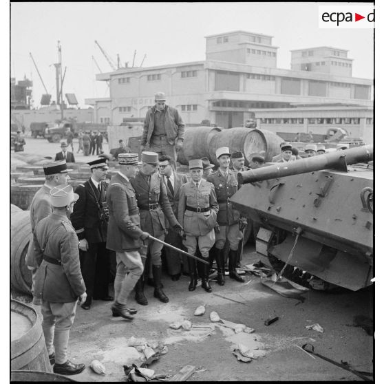 Sur une chaîne de montage sur le port d'Alger, le général de division Roger Leyer, aide-major général chargé de l'organisation, donne des informations concernant un chasseur de chars TD M10 au général d'armée Henri Giraud, commandant en chef civil et militaire, dans le cadre du réarmement de l'armée française par les Etats-Unis.