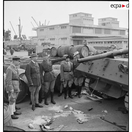 Sur une chaîne de montage sur le port d'Alger, le général de division Roger Leyer, aide-major général chargé de l'organisation, donne des informations concernant un chasseur de chars TD M10 au général d'armée Henri Giraud, commandant en chef civil et militaire, dans le cadre du réarmement de l'armée française par les Etats-Unis.
