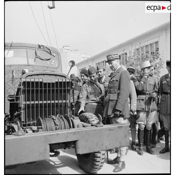 Dans le cadre du réarmement de l'armée française par les Etats-Unis, sur une chaîne de montage sur le port d'Alger, un colonel de l'armée de l'air américaine présente un camion de transport GMC au général d'armée Henri Giraud, commandant en chef civil et militaire.