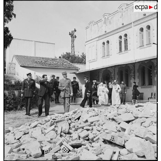 Le général d'armée Henri Giraud, commandant en chef civil et militaire, accompagné du colonel François Gonzalez de Linarès, sous-chef d'état-major, et du lieutenant de vaisseau Viret, s'enretient avec un personnel de l'orphelinat Notre-Dame d'Afrique, cible d'un bombardement dans la nuit du 17 au 18 avril 1943.