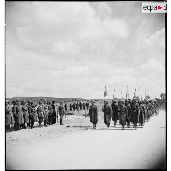 Défilé d'un détachement d'une unité de tirailleurs devant les autorités lors de l'inauguration du monument érigé à la mémoire du général de division Marie-Joseph Welvert, commandant la DMC (division de marche de Constantine), décédé au cours de la campagne de Tunisie.
