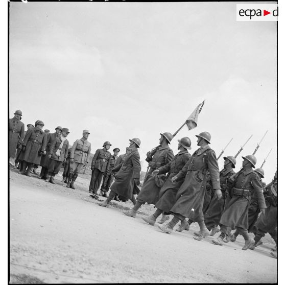Défilé d'un détachement d'une unité de tirailleurs devant les autorités lors de l'inauguration du monument érigé à la mémoire du général de division Marie-Joseph Welvert, commandant la DMC (division de marche de Constantine), décédé au cours de la campagne de Tunisie.