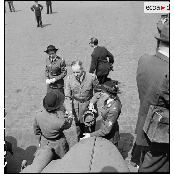 Lors de la remise d'ambulances britanniques à la Croix-Rouge française à Alger, Madame Schneider, déléguée générale, présente des conductrices ambulancières au général d'armée Henri Giraud, commandant en chef civil et militaire.