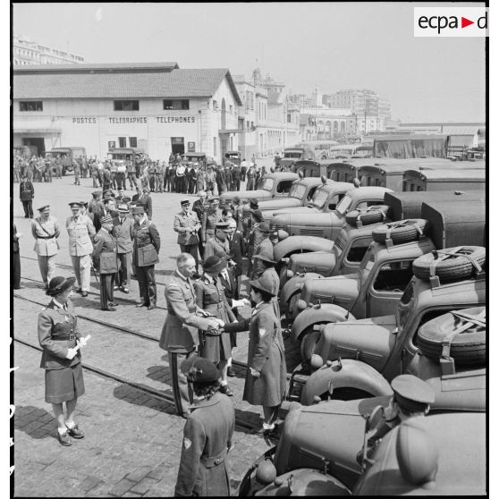 Lors de la remise d'ambulances britanniques à la Croix-Rouge française à Alger, Madame Schneider, déléguée générale, présente des conductrices ambulancières au général d'armée Henri Giraud, commandant en chef civil et militaire.