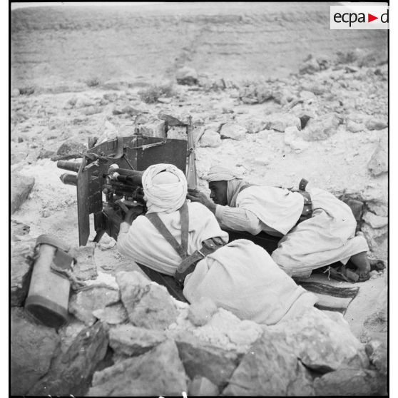 Mise en batterie d'un canon de 37 mm à tir rapide, modèle 1916, par des méharistes du groupement du capitaine Paganelli dans le secteur du FSEA (Front sud-est algérien), entre le col de Bir el Asker et le Chott el Jerid.