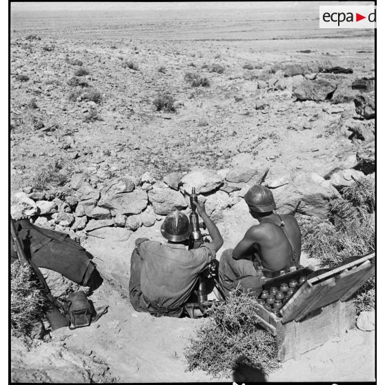 Deux légionnaires mettent en batterie un mortier de 60 mm, modèle 1935, dans le secteur du djebel el Asker, sur le FSEA (Front sud-est algérien).
