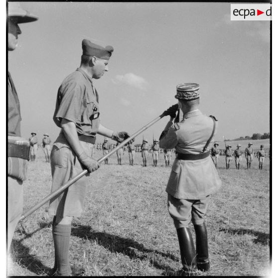 Au cours d'une prise d'armes, le général de corps d'armée Louis Koeltz, commandant le 19e CA (corps d'armée), décore de la Croix de guerre le fanion d'un escadron du 5e RCA (régiment de chasseurs d'Afrique) que lui présente son commandant.