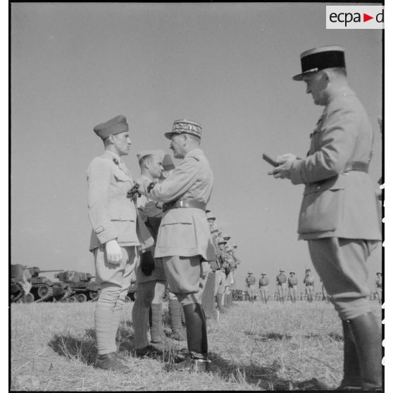 Au cours d'une prise d'armes, le général de corps d'armée Louis Koeltz, commandant le 19e CA (corps d'armée), décore des récipiendaires, ici un lieutenant, du 5e RCA (régiment de chasseurs d'Afrique), qui se sont distingués au cours de la campagne de Tunisie.
