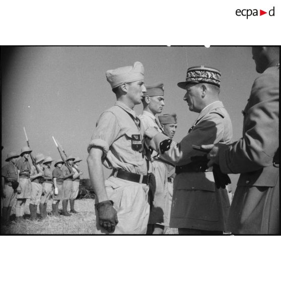 Au cours d'une prise d'armes, le général de corps d'armée Louis Koeltz, commandant le 19e CA (corps d'armée), décore des récipiendaires, ici un capitaine du 5e RCA (régiment de chasseurs d'Afrique), qui se sont distingués au cours de la campagne de Tunisie.