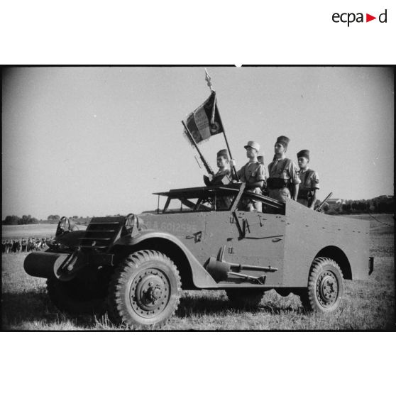 Etendard du 5e RCA (régiment de chasseurs d'Afrique) et sa garde sur un scout car M3 lors d'une prise d'armes présidée par le général de corps d'armée Louis Koeltz, commandant le 19e CA (corps d'armée).