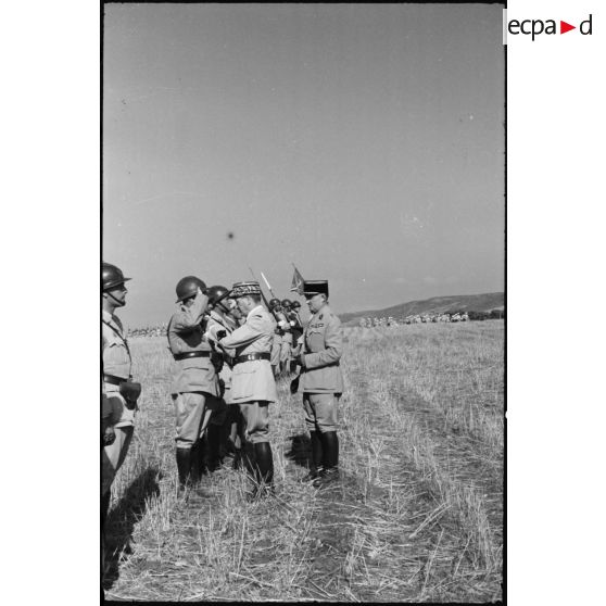 Le général de corps d'armée Louis Koeltz, commandant le 19e CA (corps d'armée), décore un officier du 1er RTA (régiment de tirailleurs algériens) au cours d'une prise d'armes.