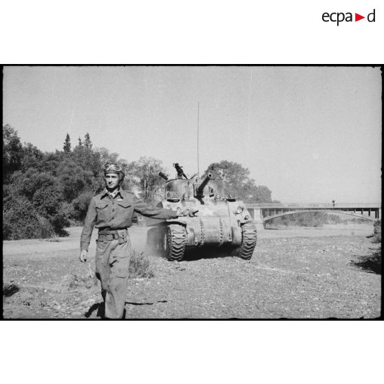 Un lieutenant, chef de char d'une unité blindée du CEF (corps expéditionnaire français), guide son char moyen Sherman M4 lors d'un entraînement dans une région désertique algérienne.