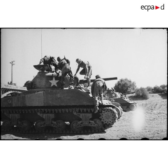 Les équipages de chars moyens Sherman M4 d'une unité blindée du CEF (corps expéditionnaire français) embarquent à bord de leurs blindés pour un entraînement de la grande unité.