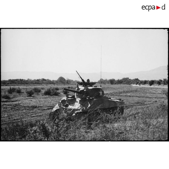 Progression d'un char moyen Sherman M4 d'une unité blindée du CEF (corps expéditionnaire français) lors d'un entraînement dans une région désertique algérienne.