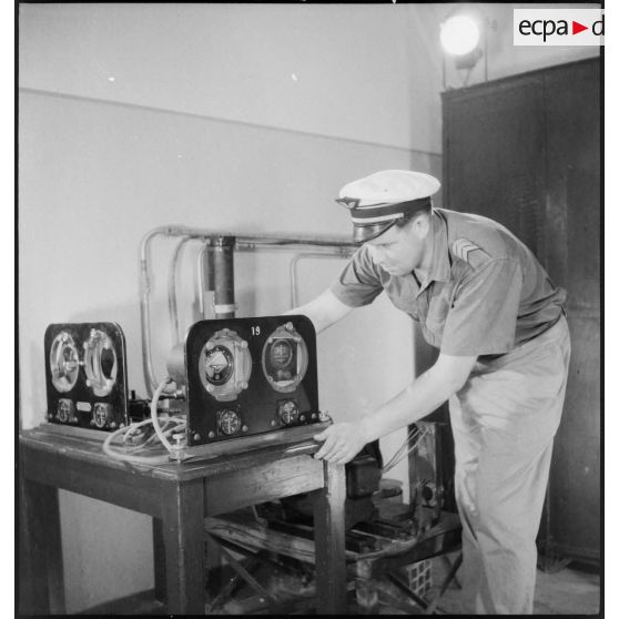 Un sergent-chef instructeur, de l'école de spécialisation du personnel navigant non pilote de l'armée de l'Air, prépare un système de pilotage automatique avant de dispenser un cours.