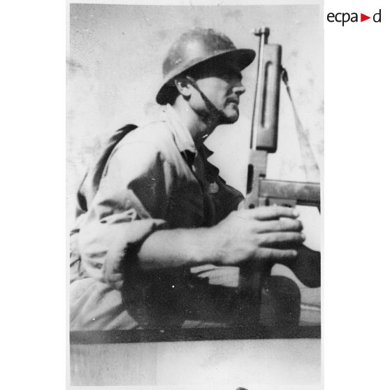 Portrait d'un soldat du CEFI (corps expéditionnaire français en Italie) équipé d'un pistolet-mitrailleur Thompson M1 lors d'un exercice de débarquement sur une plage.