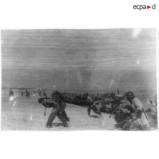 Des soldats du CEFI (corps expéditionnaire français en Italie) débarquent sur une plage en bateaux pneumatiques lors d'un exercice de débarquement sur une plage.