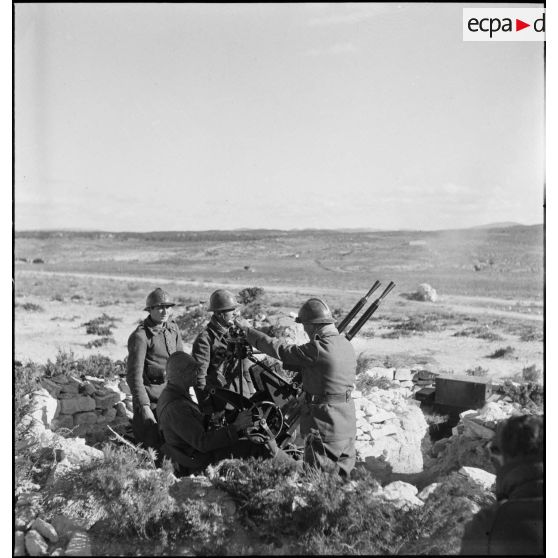 Des artilleurs du 411e RAAA (régiment d'artillerie antiaérienne) servent une mitrailleuse antiaérienne Hochkiss 13,2 mm sur affût bitube.