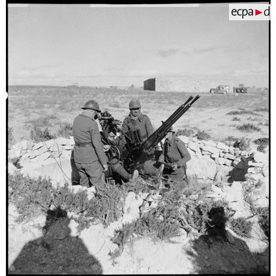 Des artilleurs du 411e RAAA (régiment d'artillerie antiaérienne) servent une mitrailleuse antiaérienne Hochkiss 13,2 mm sur affût bitube.