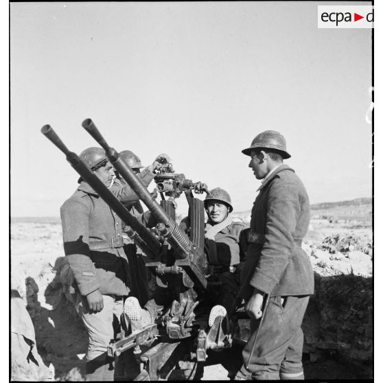 Des artilleurs du 411e RAAA (régiment d'artillerie antiaérienne) servent une mitrailleuse antiaérienne Hochkiss 13,2 mm sur affût bitube avec système de visée Le Prieur-Ricordel.