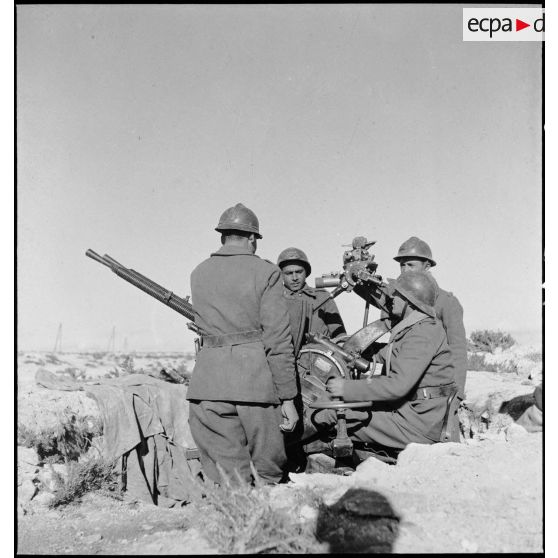 Des artilleurs du 411e RAAA (régiment d'artillerie antiaérienne) servent une mitrailleuse antiaérienne Hochkiss 13,2 mm sur affût bitube avec système de visée Le Prieur-Ricordel.