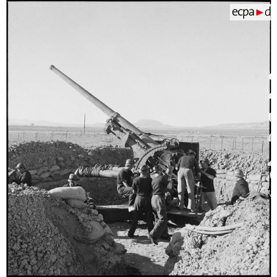 Des canonniers marins, d'une batterie mobile de 90 de marine, approvisionnent un canon de 90 mm, modèle 1939 Schneider antiaérien.