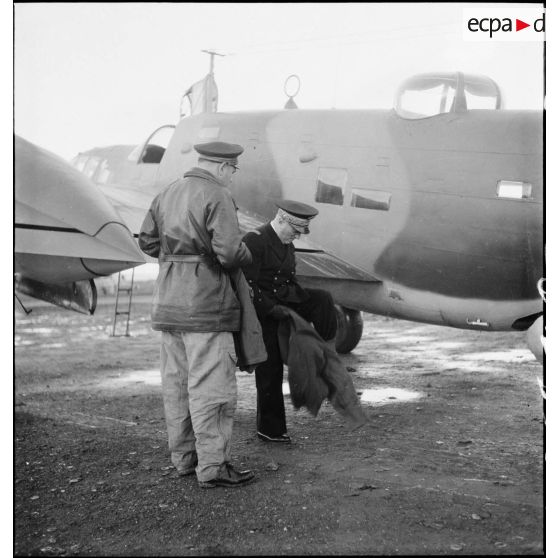 Avant d'embarquer pour Bône, l'amiral François Darlan, haut-commissaire de France en AFN (Afrique française du Nord), revêt une tenue de vol que lui a remis le lieutenant Person, pilote de l'appareil.