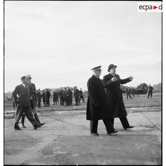 A son retour de Bône, l'amiral François Darlan, haut-commissaire de France en AFN (Afrique française du Nord), est accueilli par le contre-amiral Robert Battet, directeur du cabinet militaire du ministre de la Marine. A gauche, en civil, le commandant Hourcade discute avec le lieutenant Weiss.