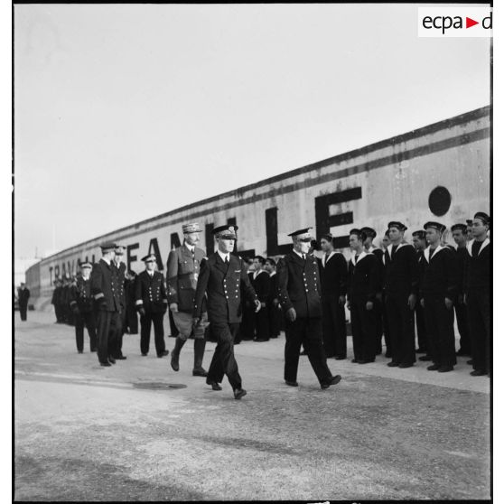 En début de cérémonie, l'amiral François Darlan, haut-commissaire de France en AFN (Afrique française du Nord) et le général d'armée Henri Giraud, commandant les forces françaises en AFN, accompagnés du vice-amiral Marcel Leclerc, commandant la Marine à Alger, passent en revue les équipages des sous-marins Casabianca, Le Glorieux et Marsouin.