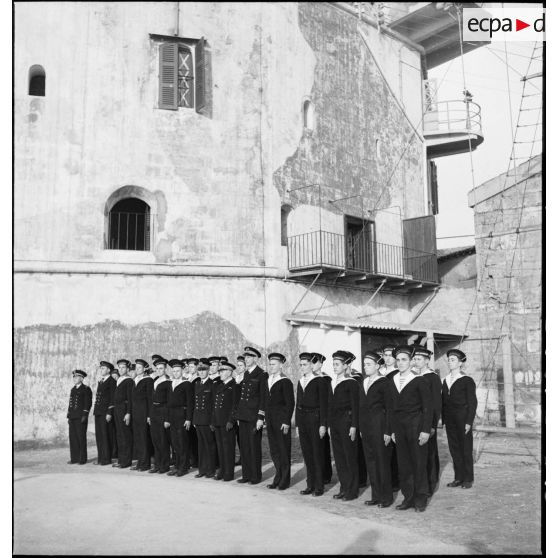Photographie de groupe de l'amiral François Darlan, haut-commissaire de France en AFN (Afrique française du Nord), du vice-amiral Marcel Leclerc, commandant la Marine à Alger et du capitaine de vaisseau Marcel Adam, commandant l'Ecole navale, avec les élèves officiers.