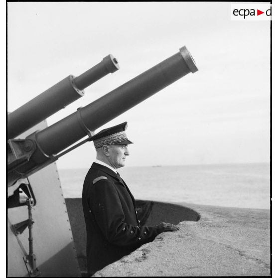 Portrait de l'amiral François Darlan, haut-commissaire de France en AFN (Afrique française du Nord), devant la tourelle d'une batterie de défense côtière dans le port d'Alger.