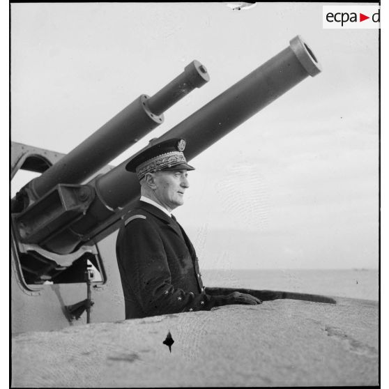 Portrait de l'amiral François Darlan, haut-commissaire de France en AFN (Afrique française du Nord), devant la tourelle d'une batterie de défense côtière dans le port d'Alger.