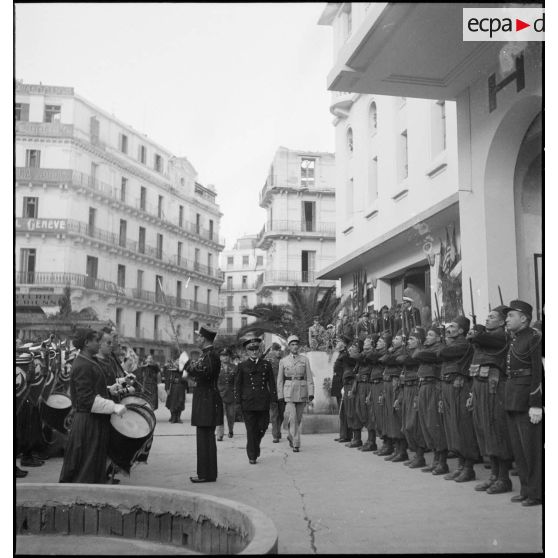 Après avoir reçu des chefs musulmans dans le cadre de la fête de l'Aïd el-Kébir, l'amiral François Darlan, haut-commissaire de France en AFN (Afrique française du Nord), se rend au cinéma Colisée pour la présentation d'un film. Un détachement et la musique du 1er RZ (régiment de zouaves) lui rendent les honneurs.
