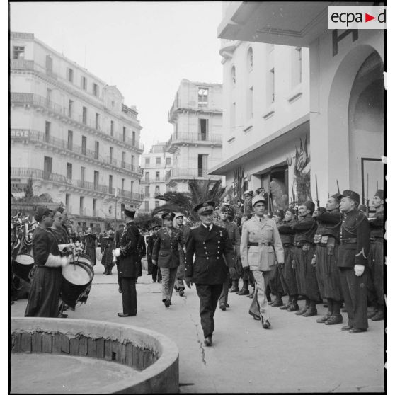 Après avoir reçu des chefs musulmans dans le cadre de la fête de l'Aïd el-Kébir, l'amiral François Darlan, haut-commissaire de France en AFN (Afrique française du Nord), se rend au cinéma Colisée pour la présentation d'un film. Un détachement et la musique du 1er RZ (régiment de zouaves) lui rendent les honneurs.