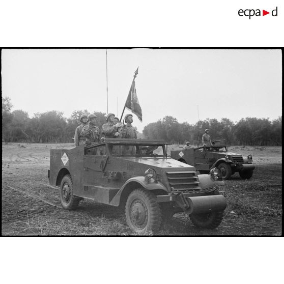 L'étendard du 1er REC (régiment étranger de cavalerie) et sa garde sont à bord d'un scout-car M3A1 lors d'une prise d'armes près de la forêt de la Mamora.