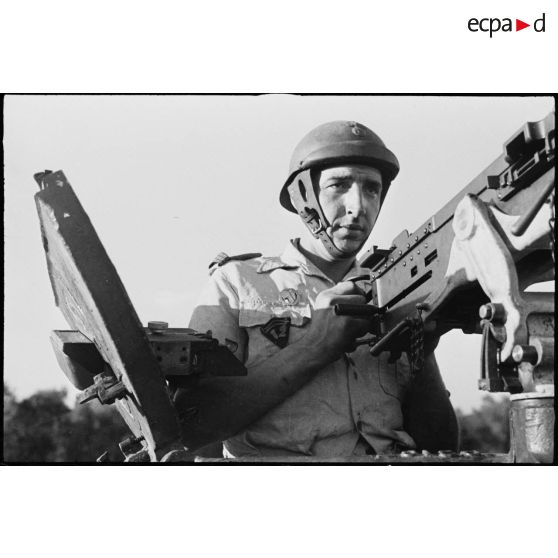 Portrtait en buste d'un capitaine du 12e régiment de chasseurs d'Afrique (12e RCA) de la 2e division blindée (2e DB) au poste de servant de la mitrailleuse Browning de 12,7 mm d'un char moyen Sherman M4.