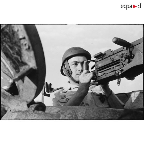Portrait d'un maréchal des logis-chef du 12e régiment de chasseurs d'Afrique (12e RCA) de la 2e division blindée (2e DB) au poste de mitrailleur dans la tourelle d'un char moyen Sherman M4 A2.