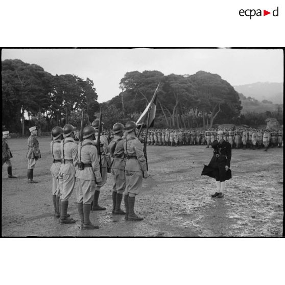 Un aumônier bénit le drapeau de l'école d'élèves aspirants de Cherchell lors du baptême de la promotion Tunisie.