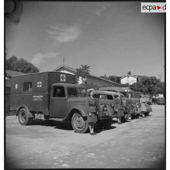 Des conductrices ambulancières du 27e escadron du Train posent devant leurs véhicules lors du rapport quotidien. Certains d'entre eux sont des ambulances Renault AGC3.