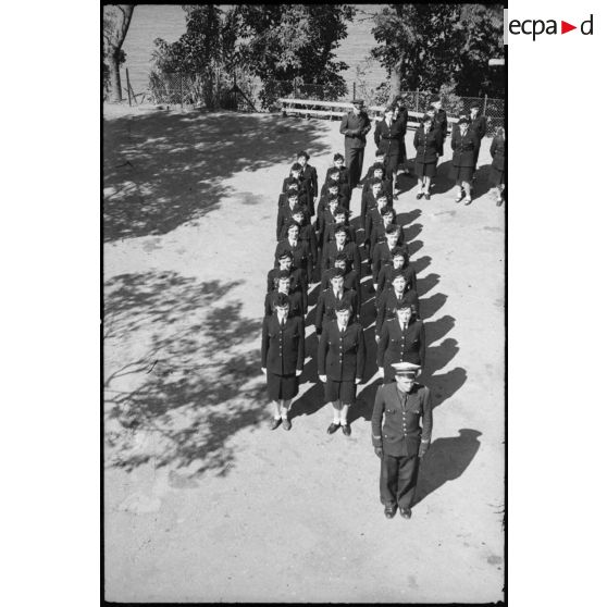 Elèves de l'école des transmissions des personnels féminins de l'armée de l'Air rassemblées dans la cour de l'école lors du rapport quotidien.