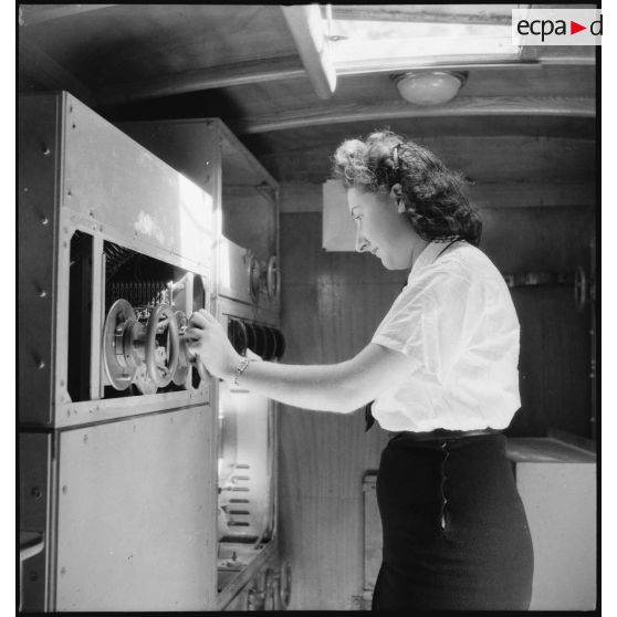 Instruction pratique de TSF pour une élève de l'école des transmissions des personnels féminins de l'armée de l'Air : écoute en voiture SIF et réglage de l'émetteur.