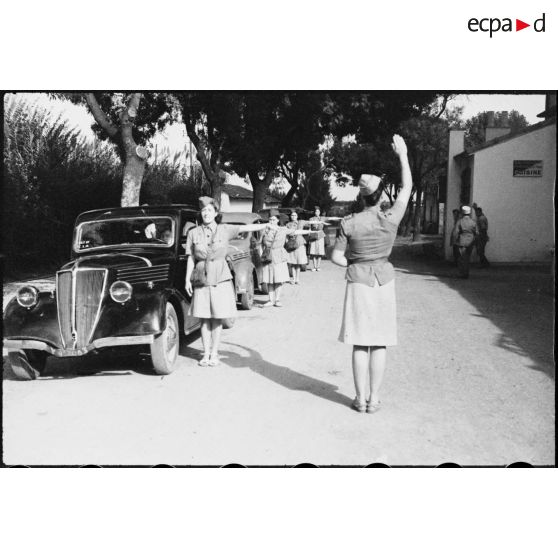 Elèves du 27e escadron du train de l'école des conductrices de Marengo avant un départ pour une leçon de conduite. Le véhicule de liaison au premier plan est une Renault Vivaquatre.