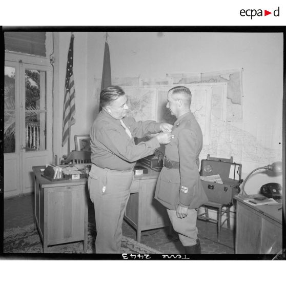 Dans un bureau, le général américain Davies remet la croix de la Légion du mérite au lieutenant-colonel Le Coq.