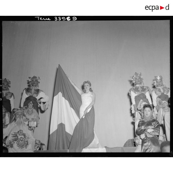 L'artiste Gisèle Grandpré, drapée dans un drapeau tricolore, chante La Marseillaise lors du tableau final du gala de l'Empire.