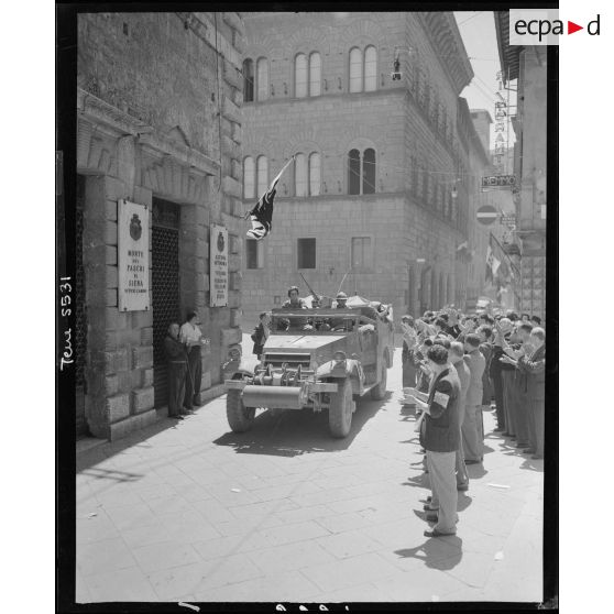Un scout-car d'une unité du corps expéditionnaire français (CEF) circule dans Sienne sous les applaudissements de la population civile.