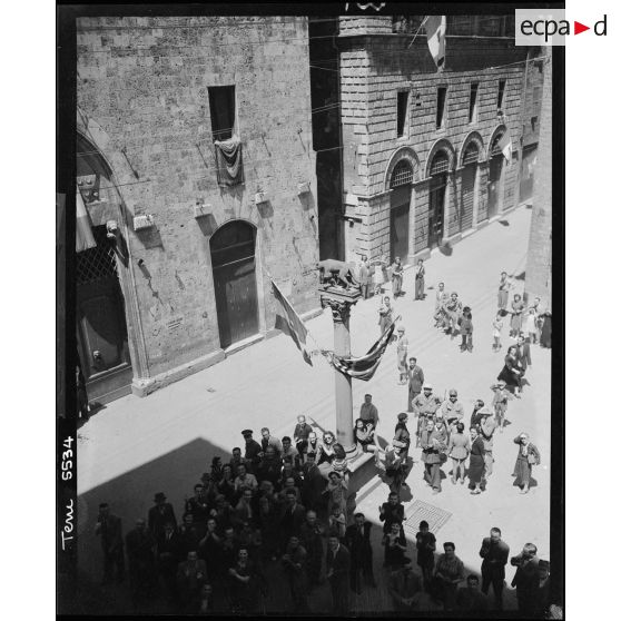 Vue en plongée sur une statue d'une louve avec Senius et Aschius, fondateurs de Sienne, fils de Remu, autour de laquelle une foule esr rassemblée.