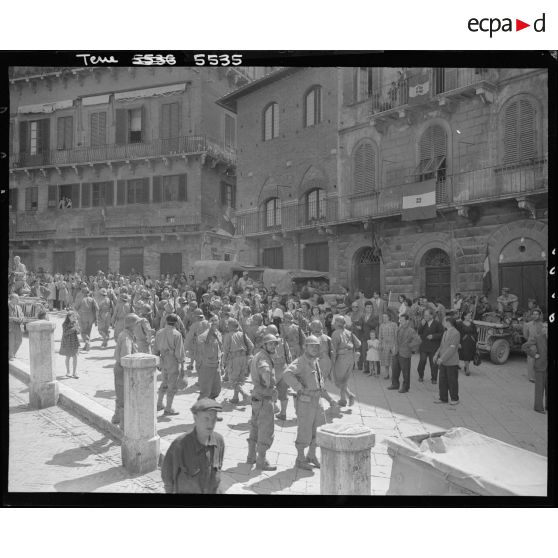 Des tirailleurs de la 3e division d'infanterie algérienne (3e DIA) sont mêlés à la population devant l'hôtel de ville avant une cérémonie sur la Piazza del Campo.