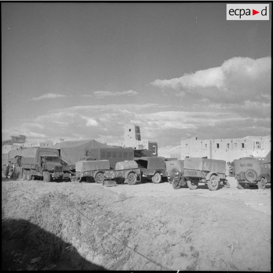 Eléments de transport de la 75e CRD (compagnie de réparation divisionnaire) groupés devant les bâtiments.