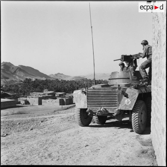Automitrailleuse en patrouille de surveillance près des bâtiments de la 75e CRD (compagnie de réparation divisionnaire).
