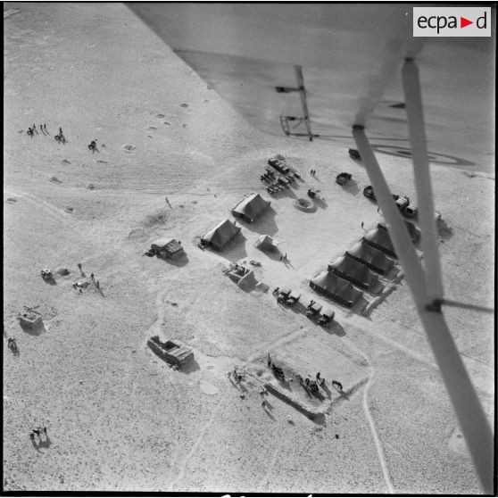 Vue aérienne d'une oasis et d'un campement militaire.